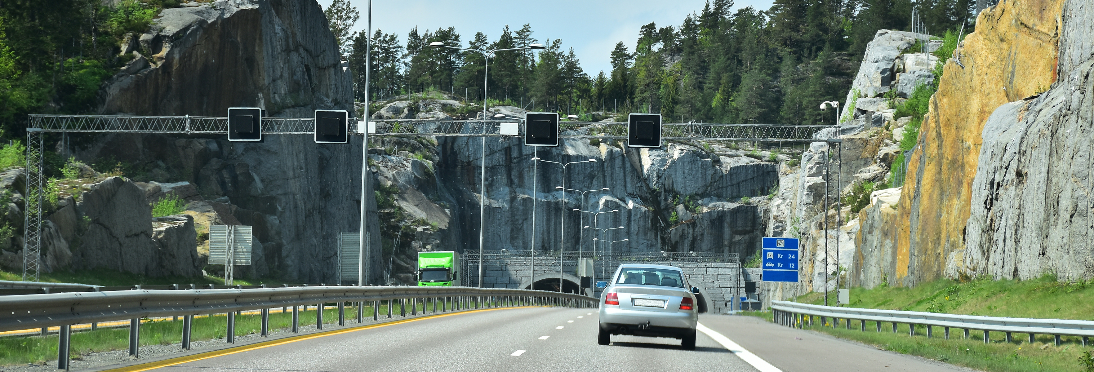 Bil som kjører gjennom en bomring og inn i en tunnel