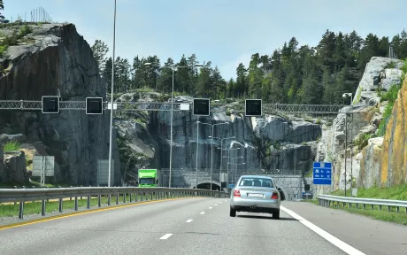 Bil som kjører gjennom en bomring og inn i en tunnel