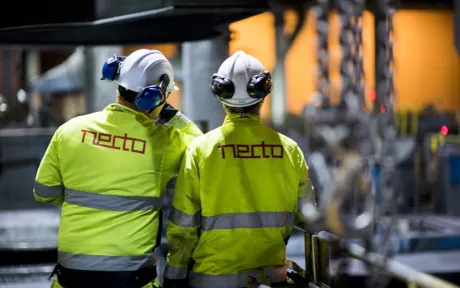 To menn i gul jakke med Nectologo på ryggen